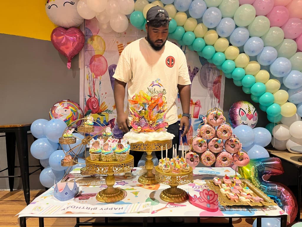 Chef Alex at a themed dessert table with custom cakes and treats